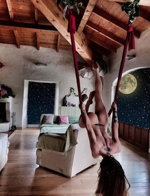 Ecco una delle foto più apprezzate: Naike pratica yoga, nuda come sempre, aggrappandosi a delle corde appese sul soffitto.