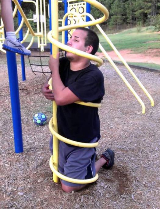 Vedendo questa foto, viene spontaneo chiedersi come abbia fatto questo ragazzo a rimanere intrappolato in questo gioco per bambini, 