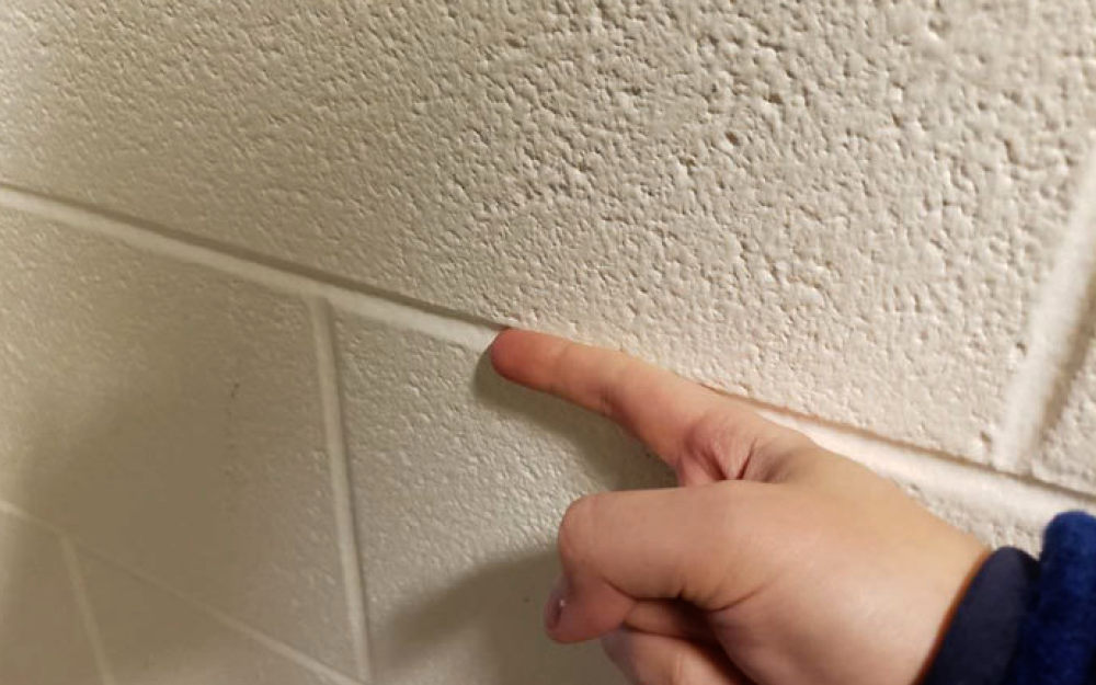 Passare il dito sulla scanalatura del muro