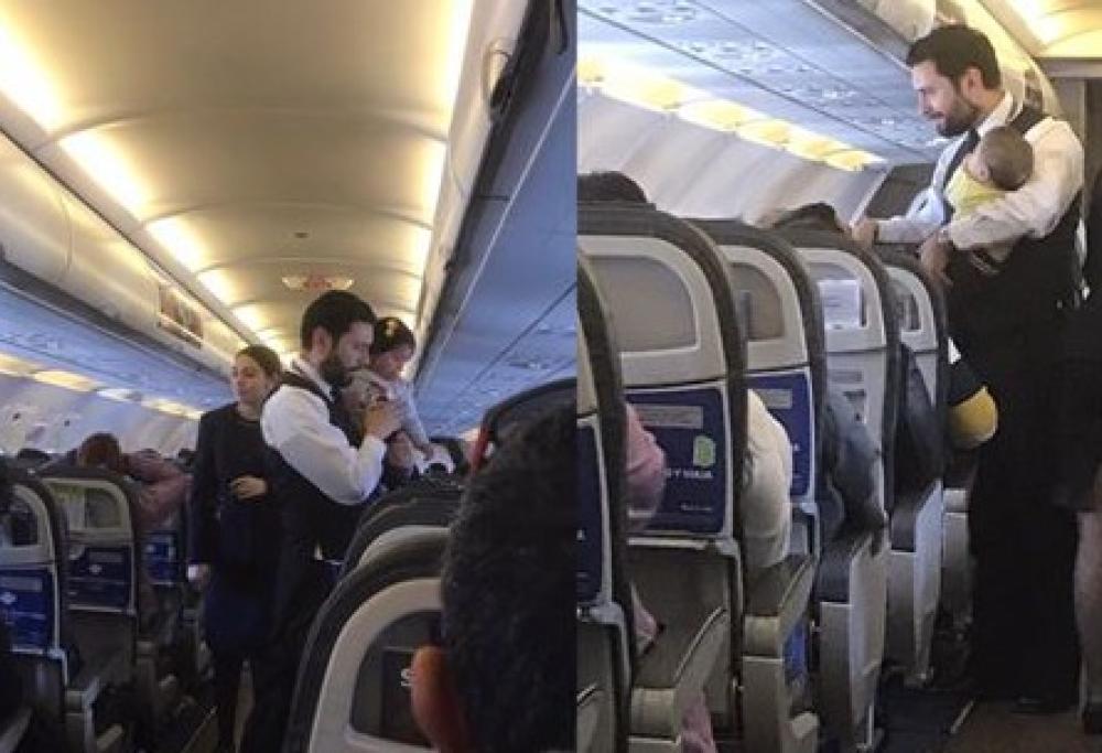L’assistente di volo prende in braccio il bambino per farlo calmare, ecco lo scatto che commuove il web