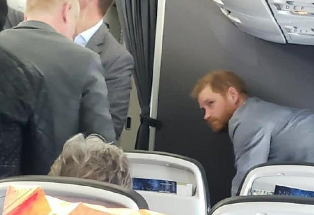 Il principe Harry immortalato su un volo di linea per Londra