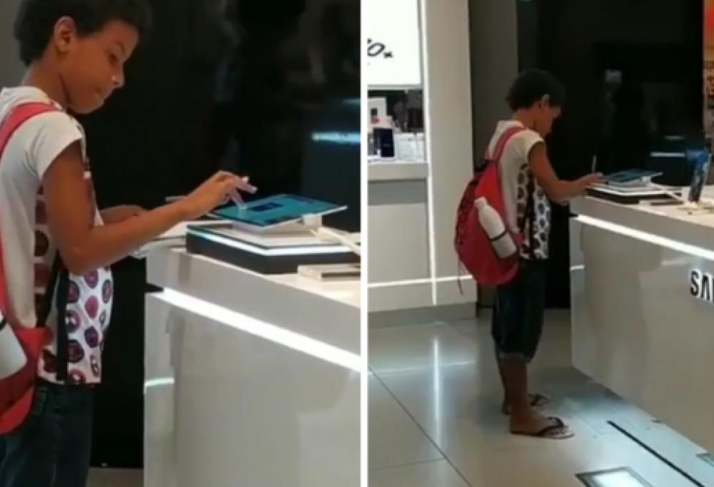 Bimbo povero usa il tablet esposto in un negozio per fare i compiti