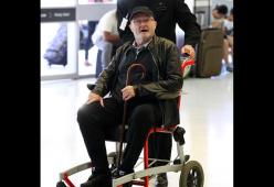 Phil Collins in sedia a rotelle all’aeroporto di Sydney
