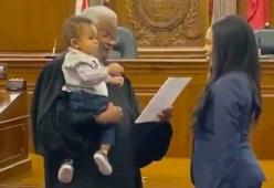 Il giudice le tiene in braccio il figlio durante il giuramento da avvocato: il video è bellissimo