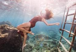 La modella che fa lo shooting tra gli squali nell'Oceano: il video